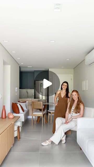 Sala integrada com mobiliário claro, iluminação e vista para o exterior